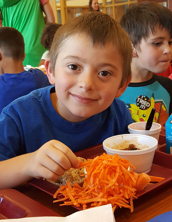 web Uriah Wilson (Kindergarten) takes a break from his quinoa- carrot muffin to munch on some carrot shreds 